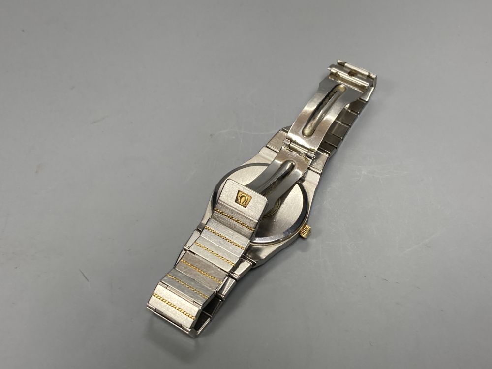 A gentlemans stainless steel and yellow metal Omega Constellation quartz wrist watch, with black dial and baton numerals,